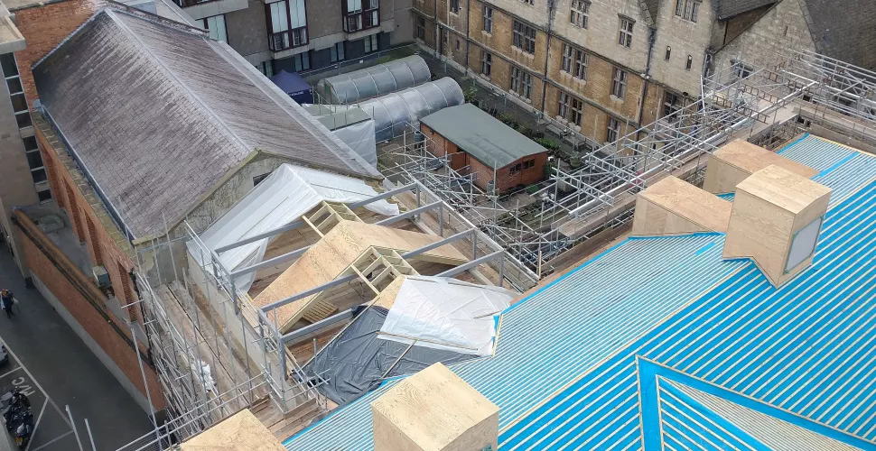 An aerial view of the roof of the Levine Building. It is covered in blue plastic sheeting.